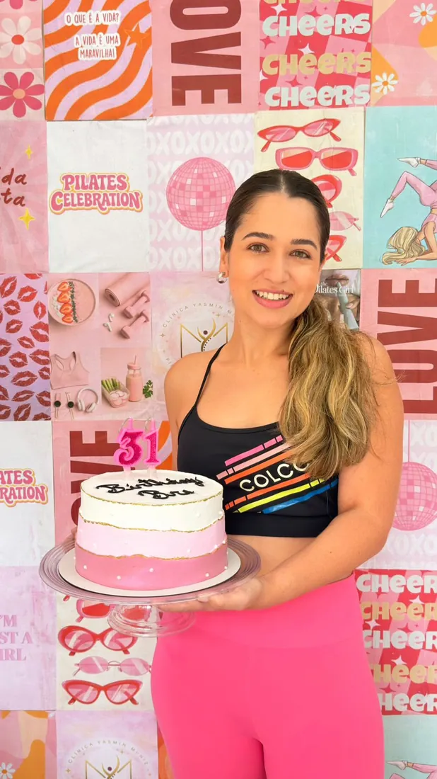 Aniversariante segurando o bolo de aniversário no Pilates Celebration