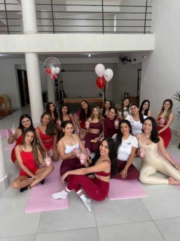 Grupo de mulheres reunidas com balões e drinks durante a confraternização do Pilates Day